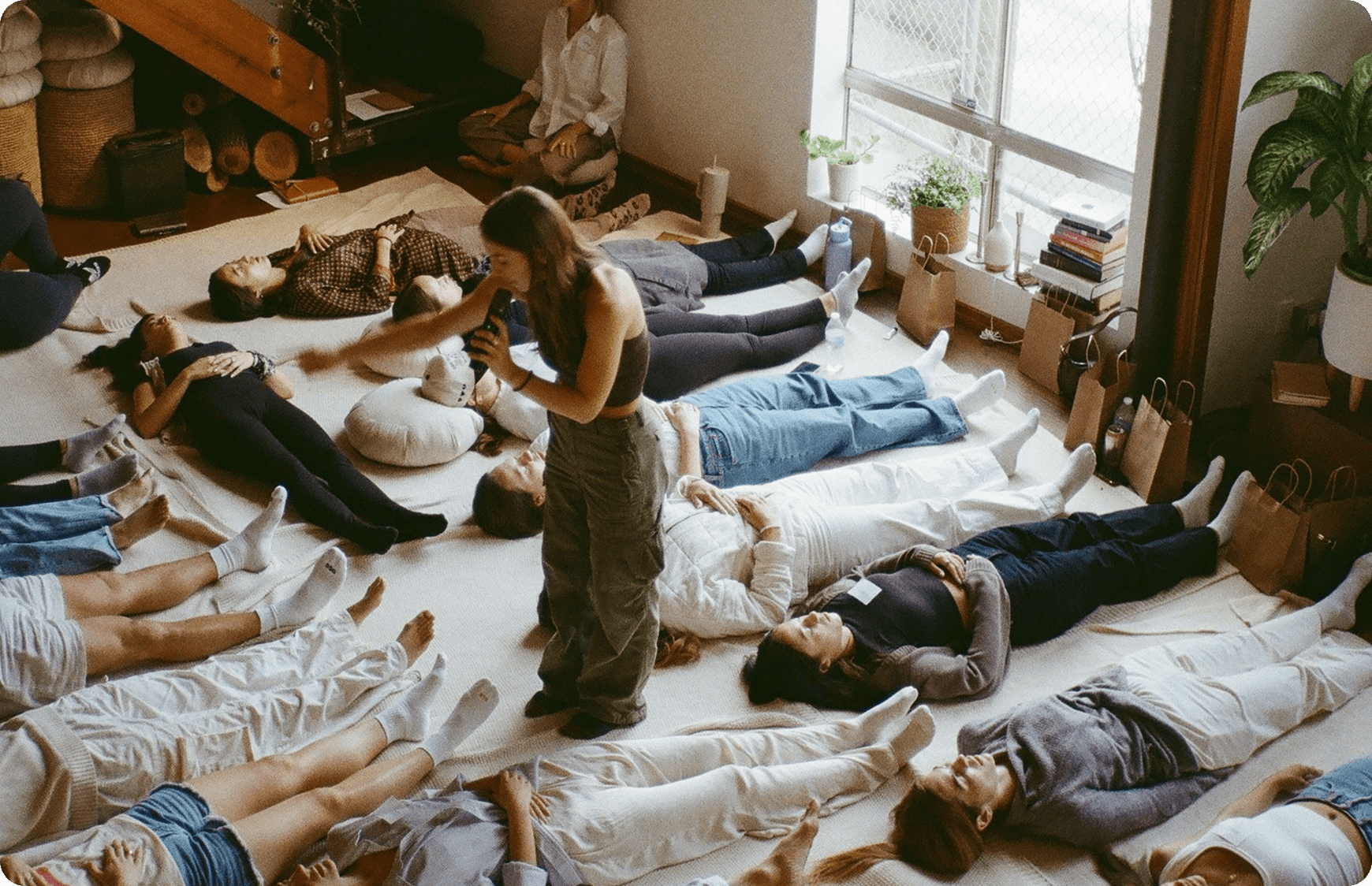 A sound healing session at Moss with participants lying on the floor under a facilitator’s guidance