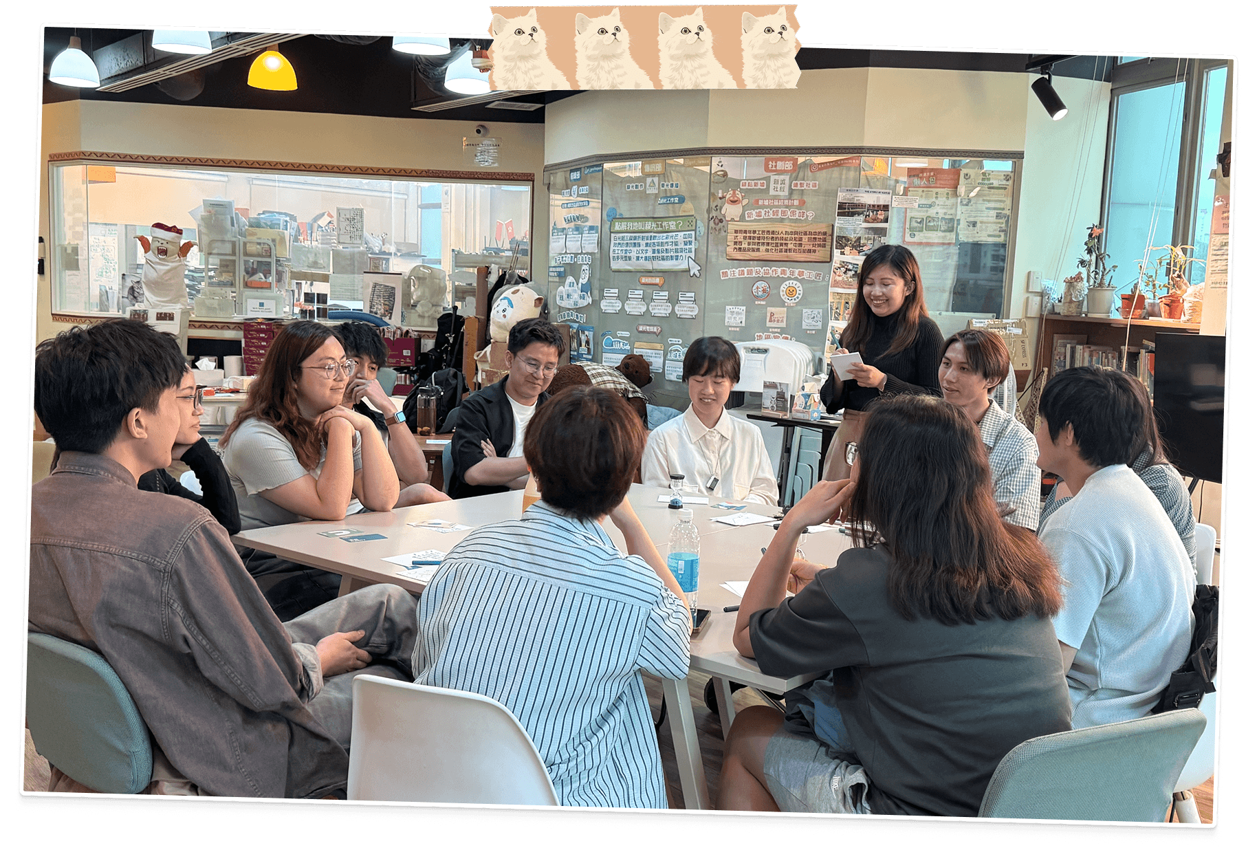 Participants seated in a circle around low tables at World Cafe CAT while Shirley facilitates a session